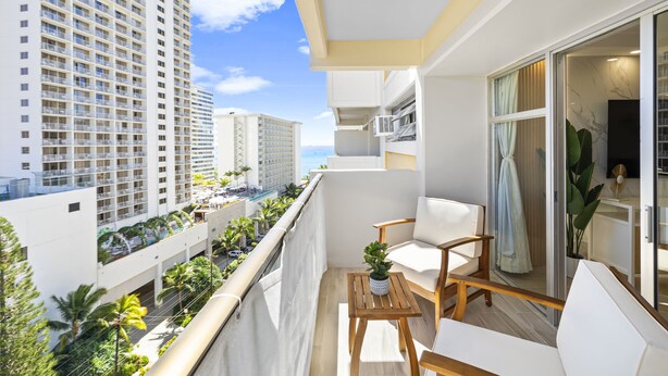 A balcony with a view of tall buildings and a clear sky. - High Floor 2BR/2BA+Den 4beds Partial Ocean View + 1 Parking 2 min from the Beach (Honolulu)