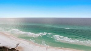 Une plage à l’eau turquoise et limpide, bordée d’un rivage sablonneux.