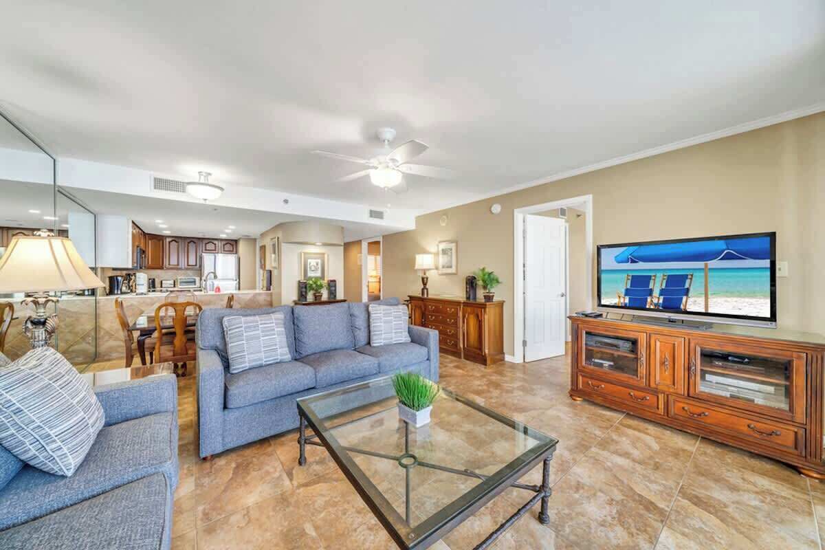A spacious living room with a sofa, coffee table, and TV.