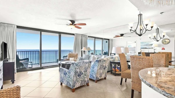 A spacious balcony with a view of the ocean, furnished with wicker chairs and a round table.