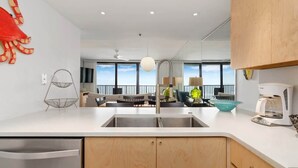 A modern kitchen with a large window, a sink, and a coffee maker.