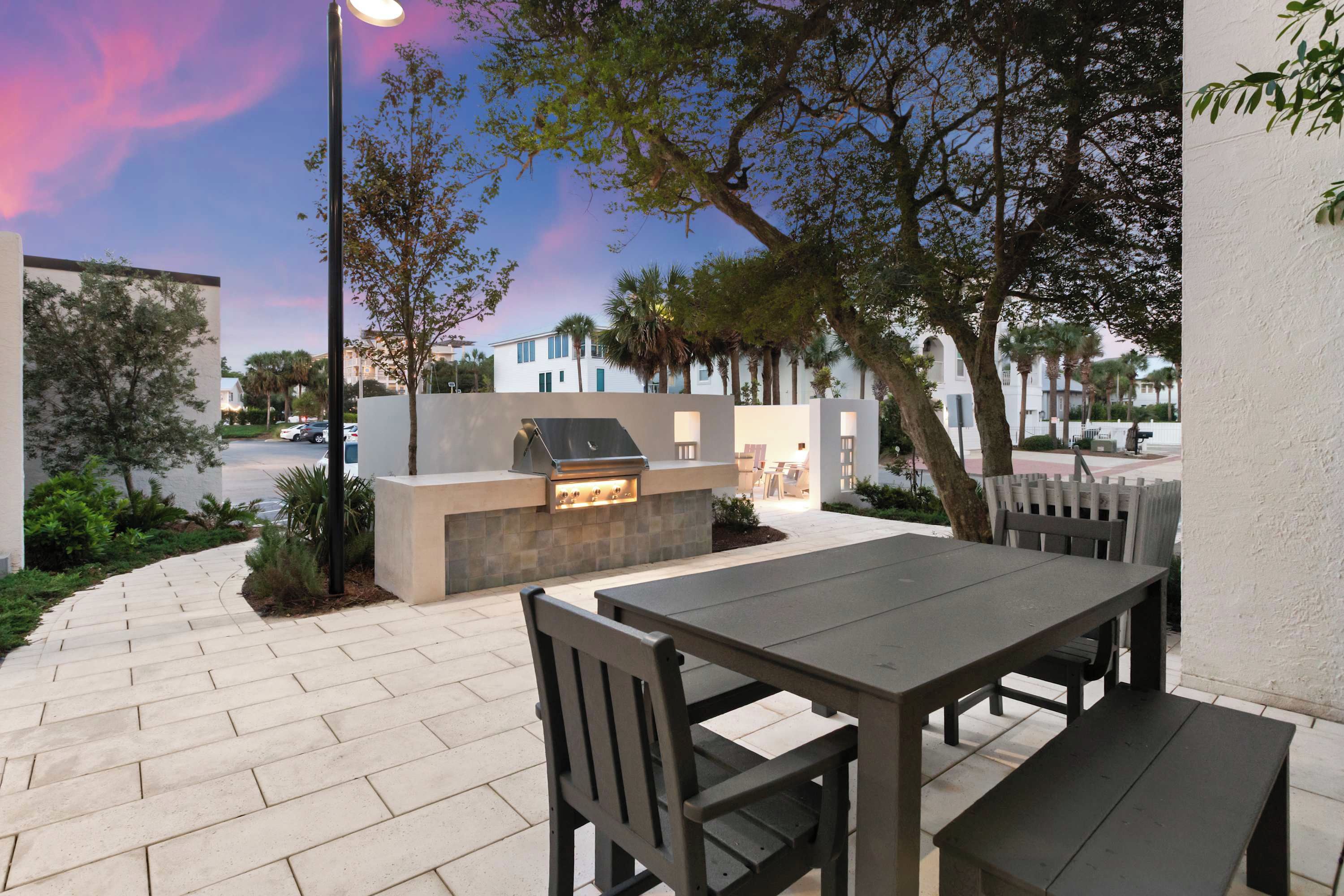 Eine Terrasse im Freien mit einem Grill, Sitzgelegenheiten und Blick auf die Straße.