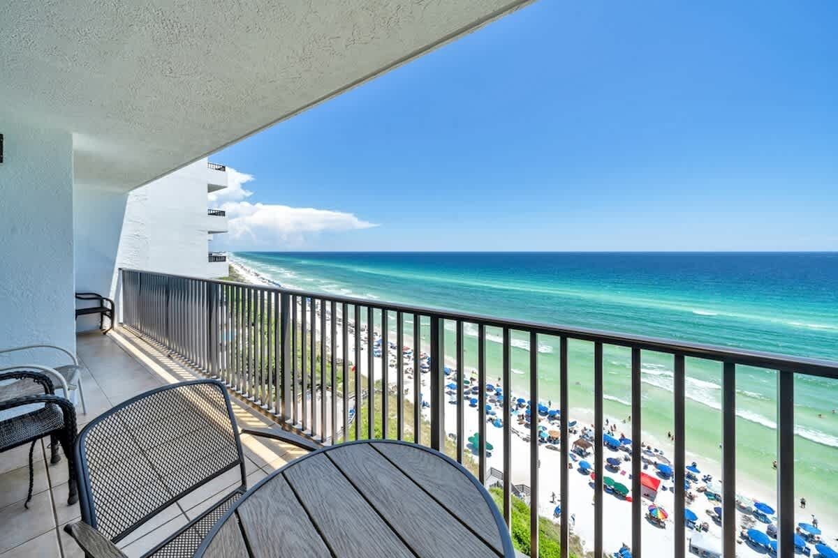 A balcony with a view of the ocean and beach.