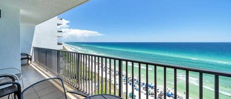 A balcony with a view of the ocean and beach.
