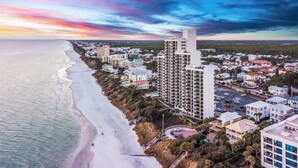 An aerial view of a coastal town with a beachfront, high-rise buildings, and a mix of residential and commercial structures. - One Seagrove Place 0405 (Santa Rosa Beach)