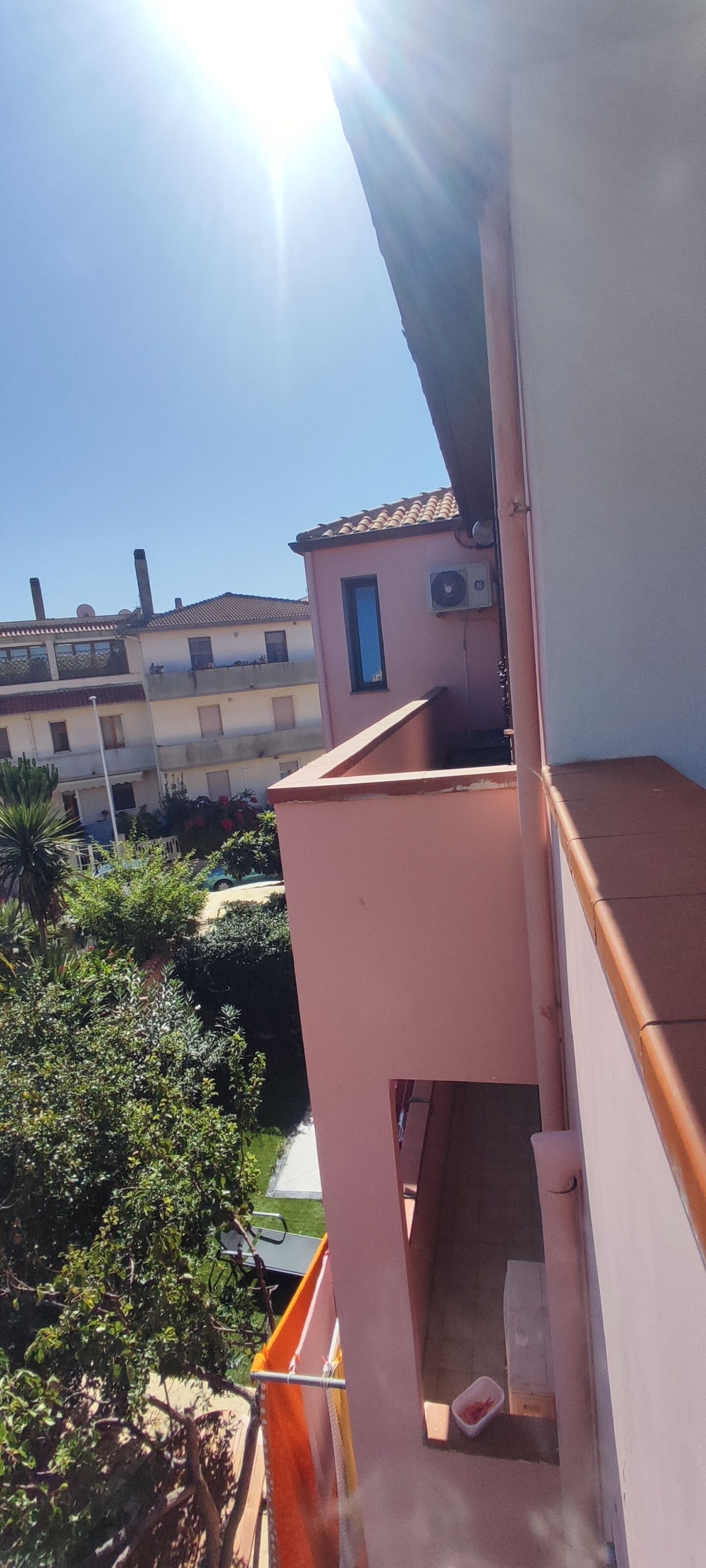 Ein Wohngebäude mit Balkon, kleinem Fenster und Klimaanlage.