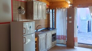 Une chambre confortable avec un lit, une kitchenette et une vue sur l’extérieur.