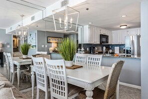 Enjoy meals in the kitchen and dining area with a white table, stainless steel appliances, and potted plants.