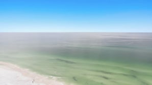 A panoramic view of a beach with clear skies and calm waters.