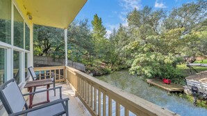 A covered outdoor area with a wooden deck, a table, and chairs. - The Bird Nest- Bunkhouse, Sports Court, & Kayaks (Kingsland)