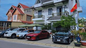 A hotel with multiple floors, balconies, and a flag. - Hai An villa Hotel (Lam Vien - Da Lat)