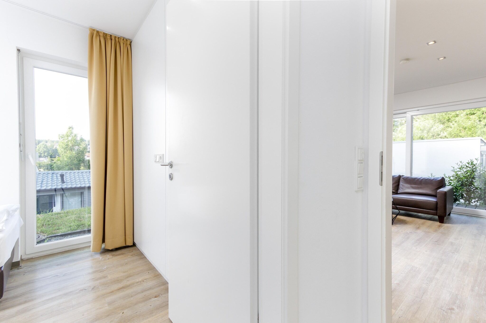 A modern room with a large sliding glass door leading to a balcony.
