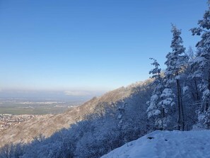 Eine verschneite Berglandschaft mit freiem Blick auf eine Stadt im Tal.