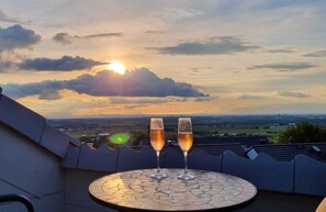 Two glasses of champagne on a tiled table with a scenic view of the sunset and landscape. - Moderne Ferienwohnung mit Atemberaubender Aussicht bei Heidelberg (Dossenheim)