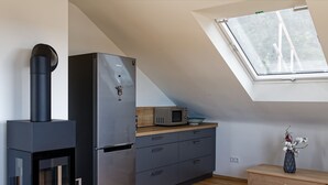 A modern kitchen with a built-in stove, refrigerator, microwave, and wooden countertop. - Moderne Ferienwohnung mit Atemberaubender Aussicht bei Heidelberg (Dossenheim)
