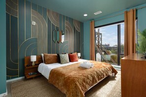 A modern hotel room with a large bed, a desk, and a view of a bridge.