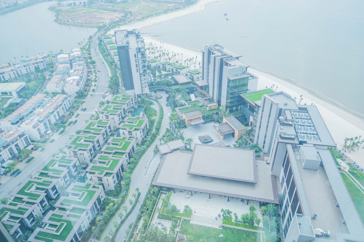 A modern hotel with a central courtyard, a beach view, and a marina.