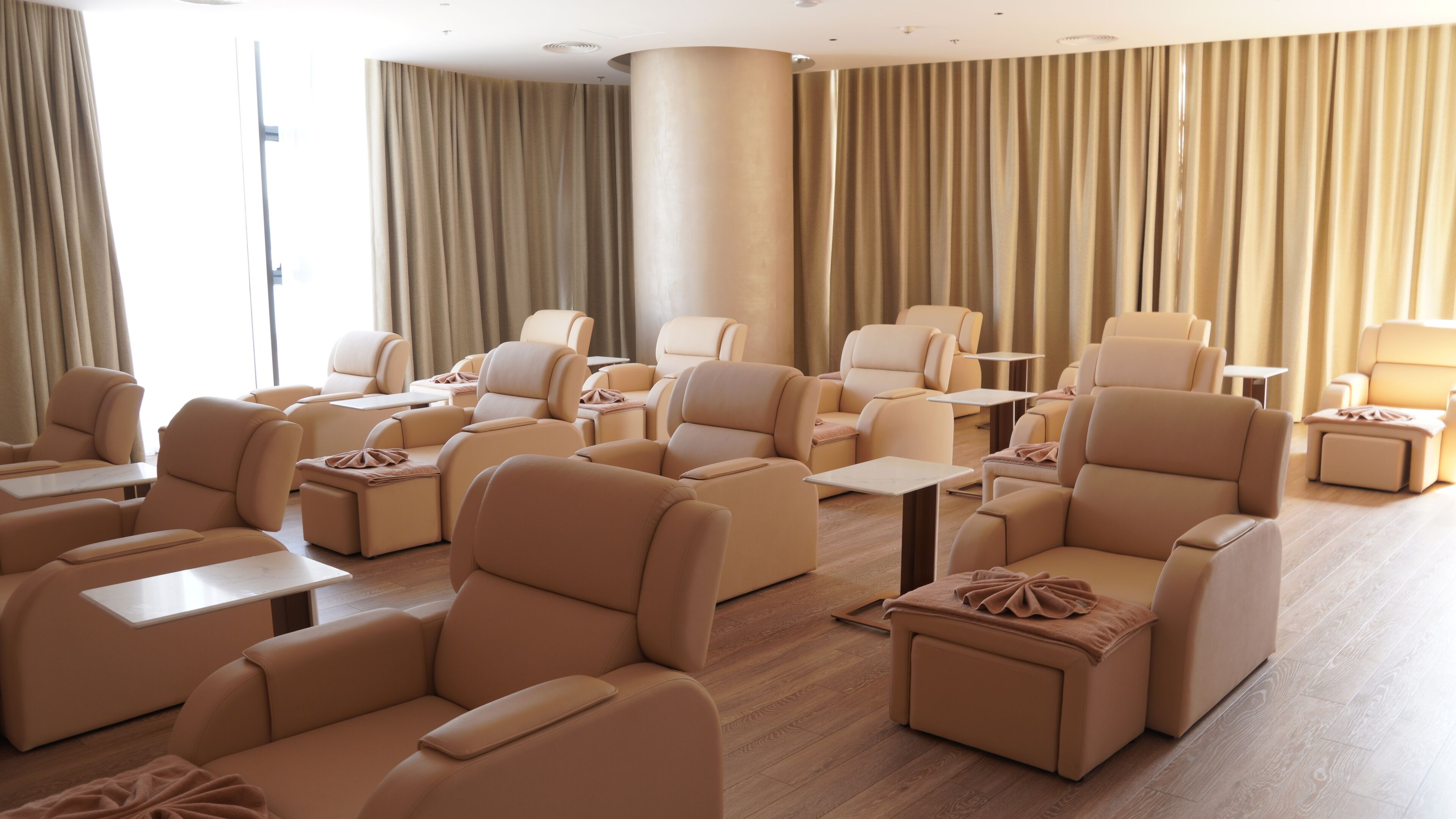 Amplia habitación con varias zonas de estar, incluyendo sofás y sillones, distribuidos alrededor de mesas.