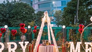 A wedding setup with a red carpet, illuminated letters spelling "MARRY ME", and heart-shaped balloons. - Posh Garden Inn (Gurugram)