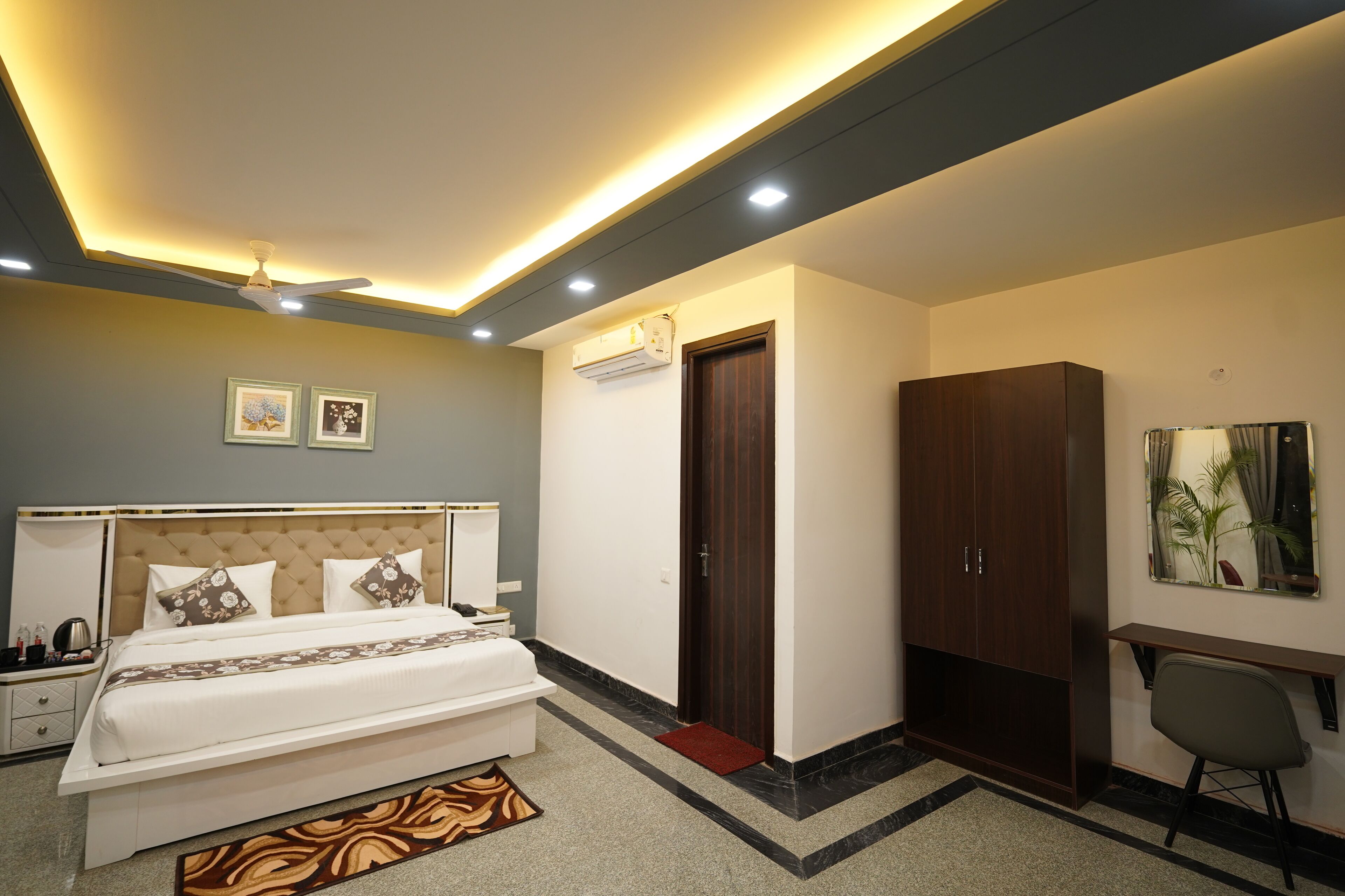A modern bedroom with a bed, bedside table, wardrobe, and a desk with a chair.