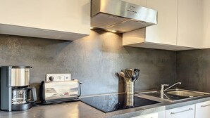A modern kitchen with a Bosch range hood, a coffee maker, a toaster, and a sink. - Apartment in central Chamonix - 6 people, parking, 3-star comfort (Chamonix-Mont-Blanc)