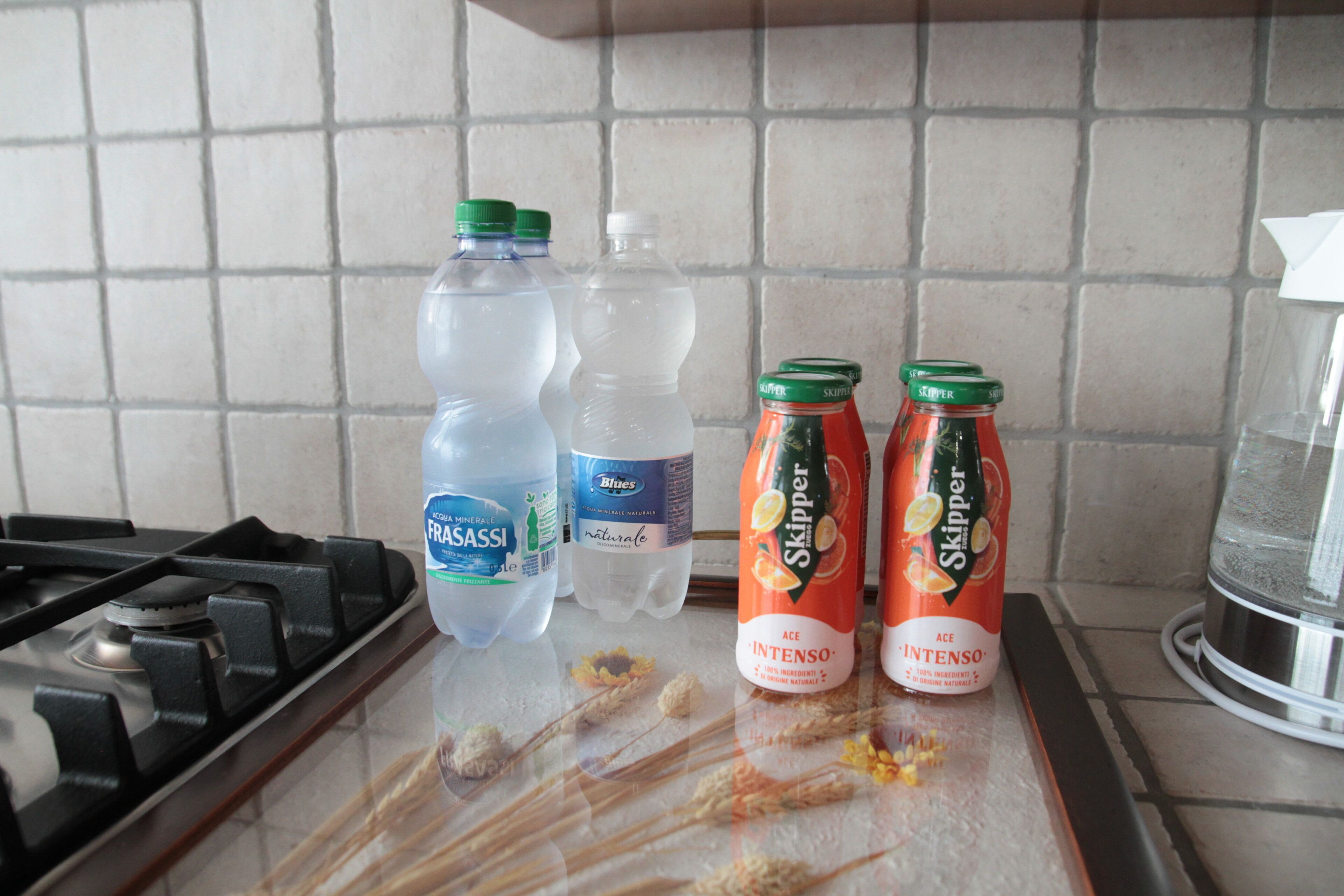 A kitchen counter with bottles of water and orange juice.