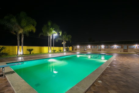Una piscina al aire libre de temporada, sombrillas