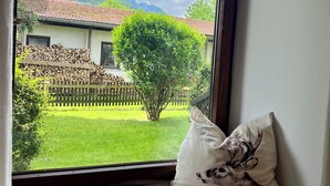 A window with a view of a house, a tree, and a mountain. - Ferienwohnung Almglück, Separates Schlafzimmer, Küche, Terrasse, TV, Wlan (Rottau)