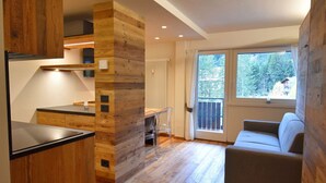 A modern kitchen with wooden accents, a dining area with a view, and a cozy seating area.