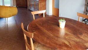Comedor con mesa de madera, sillas y una pequeña planta en maceta.