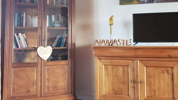 Un mueble de madera con estanterías y un televisor de pantalla plana en la parte superior.