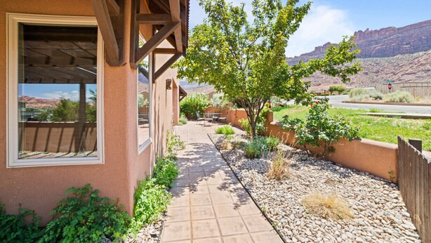 A house with a patio, a tree, and a view of the desert landscape. - Red Rock Oasis I Large Patio I Pool & Hot Tub I Views (Moab)
