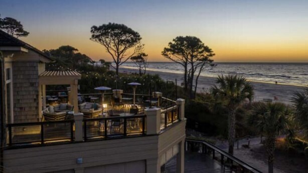 A beachfront property with a balcony overlooking the sea, outdoor seating, and a staircase leading to the entrance. - Muirfield RANCH/ On #2 Golf Links / Pool / Walk to HARBOUR TOWN/ 4 Bikes / Pet (Hilton Head Island)
