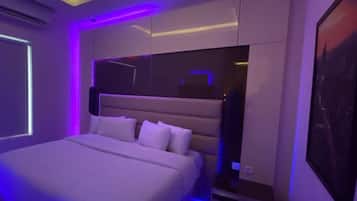 A modern bedroom with a large bed, built-in storage, and ambient lighting.
