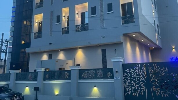 A modern building with the sign "Dreams" on the top. It has multiple floors with balconies and windows. - DREAMS BY DV8 (Lagos)
