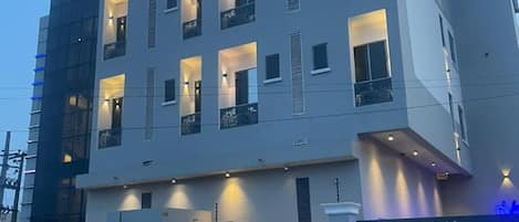 Un edificio moderno con el letrero "Dreams" en la parte superior. Tiene varios pisos con balcones y ventanas.