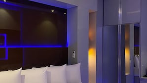 A modern bedroom with a large bed, a dark headboard, and a glass cabinet. - DREAMS BY DV8 (Lagos)