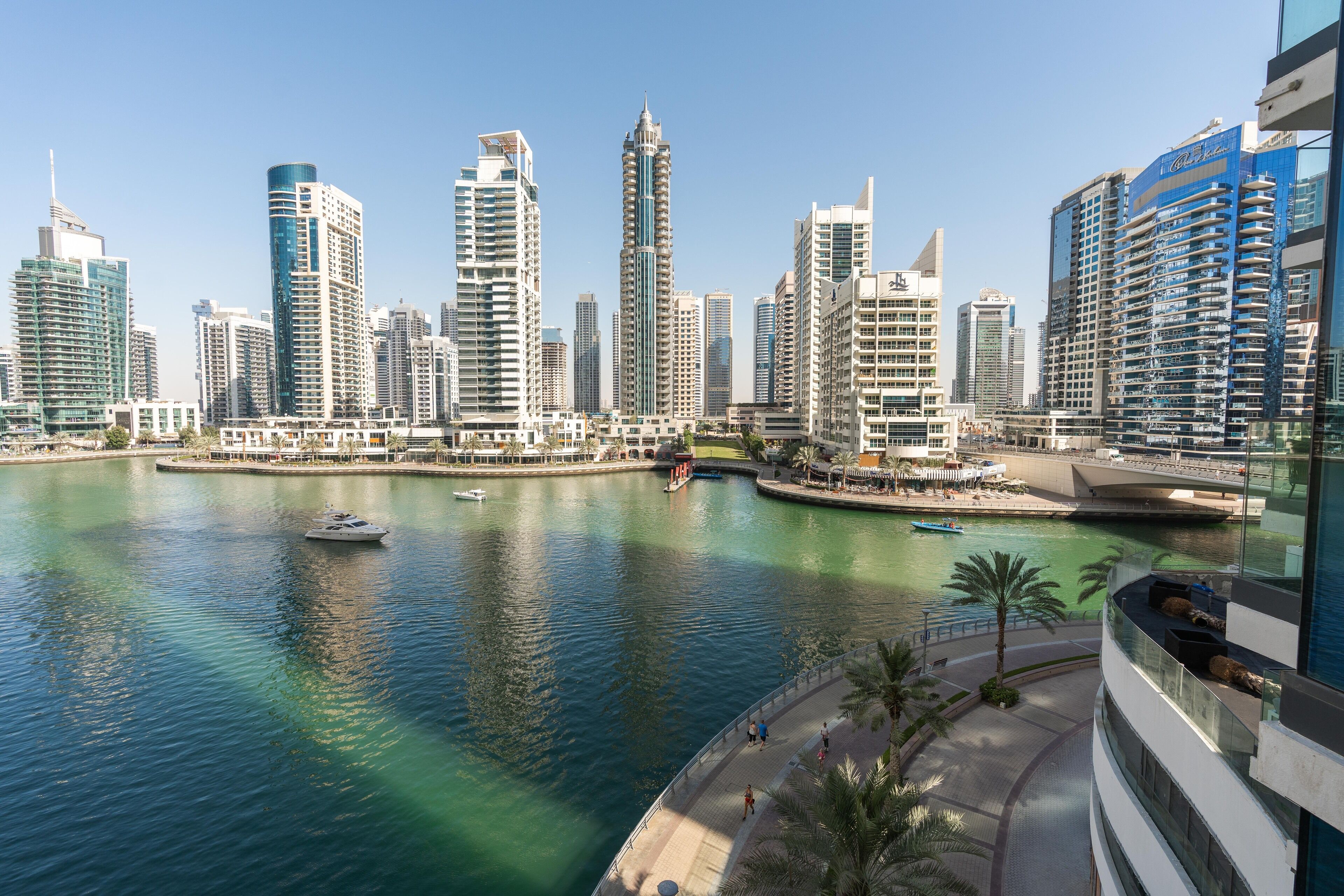 A high-rise hotel overlooking a marina with a clear view of the water and surrounding buildings.