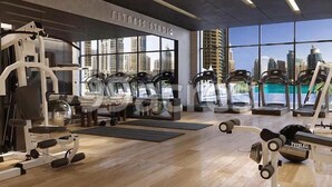 Un gimnasio moderno con máquinas de cardio, equipo de levantamiento de pesas y grandes ventanales con vistas a la ciudad.