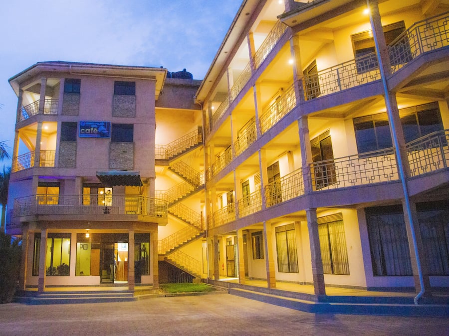 Un hotel a più piani con balconi, un caffè e un ingresso luminoso.