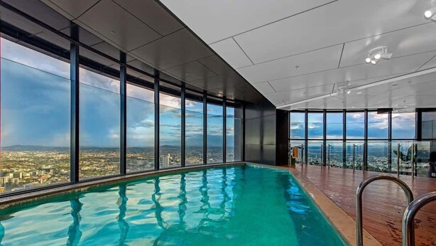 Ein moderner, überdachter Pool mit großen Fenstern und Blick auf die Stadt.