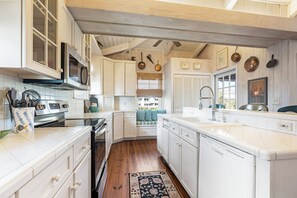A kitchen with white cabinetry, a built-in oven, and a dishwasher. - Oceanfront Beach House, Sundeck, Gazebo, Boardwalk, Screened Porch with Rockers (Pawleys Island)