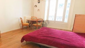 Una habitación con cama, una mesa de comedor con sillas y una ventana con vistas.