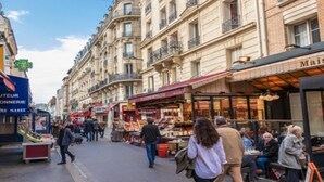 Una animada escena callejera con cafés y tiendas al aire libre.