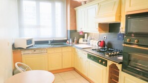 Una cocina equipada con microondas, estufa, horno y pileta.