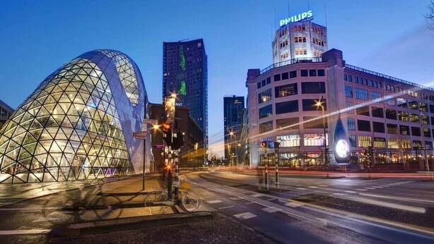 A cityscape with modern architecture, including a distinctive dome-shaped building and a high-rise with a Philips sign. - Luxurious 35m² Designer Studio (R-51-A) (Eindhoven)