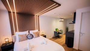 A modern hotel room with a neatly made bed, a desk, and a dining area. - Luxurious 35m² Designer Studio (R-51-A) (Eindhoven)