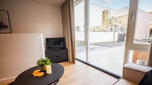 A modern room with a flat-screen TV, a small table with a plant, and a sofa. - Historical City Retreat with Sauna option (R-51-B) (Eindhoven)