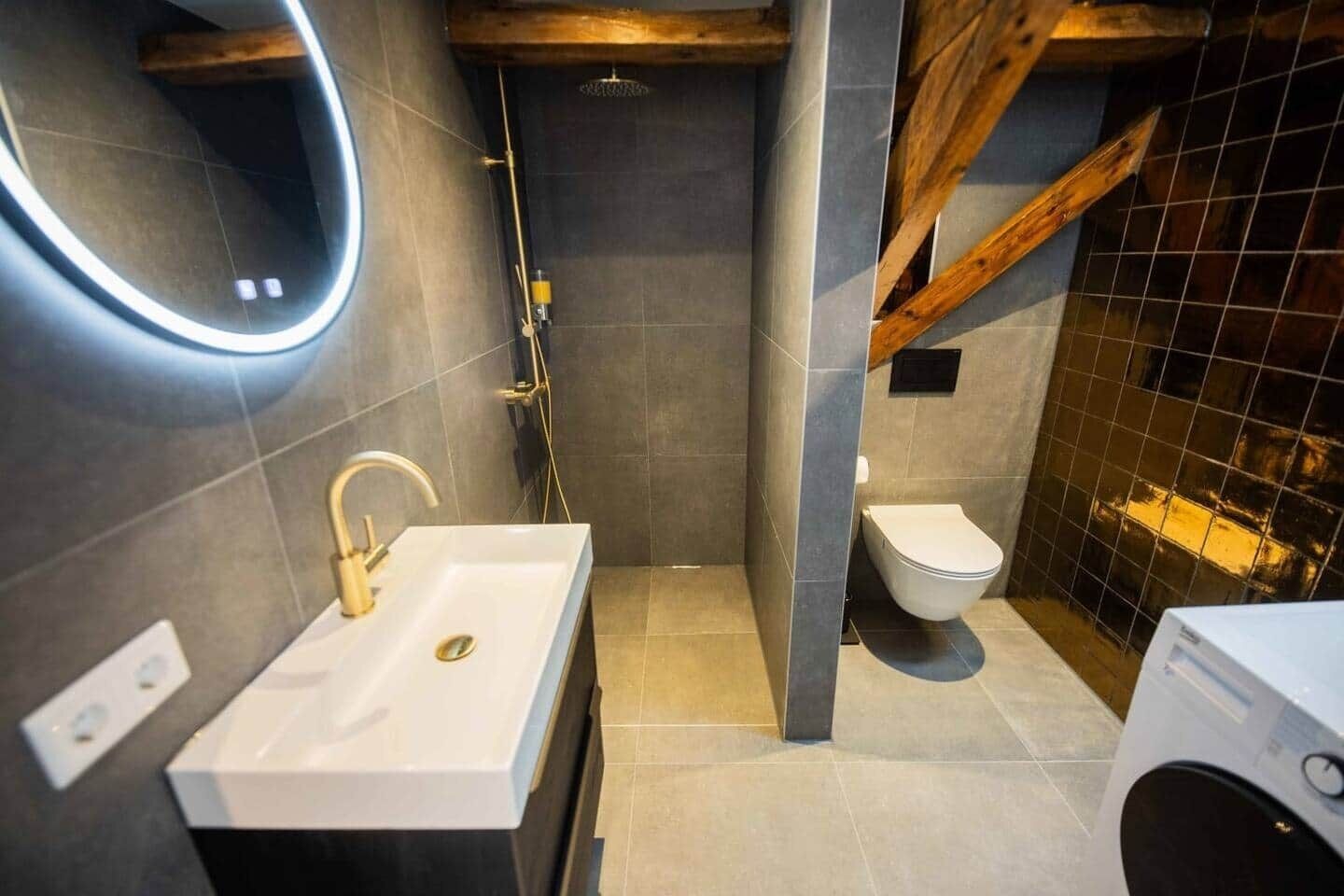 Un baño moderno con un lavabo blanco, un inodoro y una ducha.
