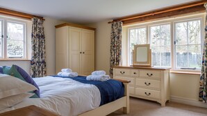 A bedroom with a bed, a dresser, a mirror, and a window with curtains. - Bull Pen - sleeps 10 guests  in 5 bedrooms (Graythwaite)